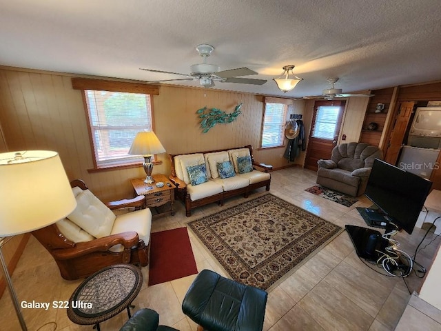 living room with ceiling fan and a textured ceiling