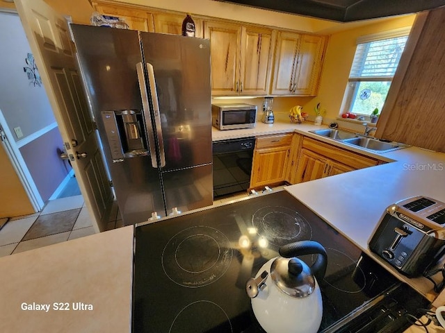 kitchen with light tile patterned flooring, stainless steel appliances, and sink