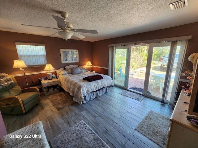 bedroom featuring hardwood / wood-style flooring, access to exterior, and a textured ceiling