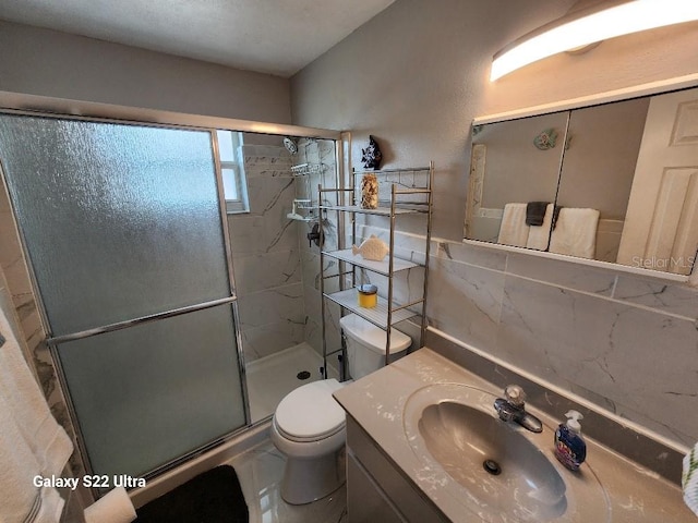 bathroom featuring vanity, toilet, an enclosed shower, and backsplash