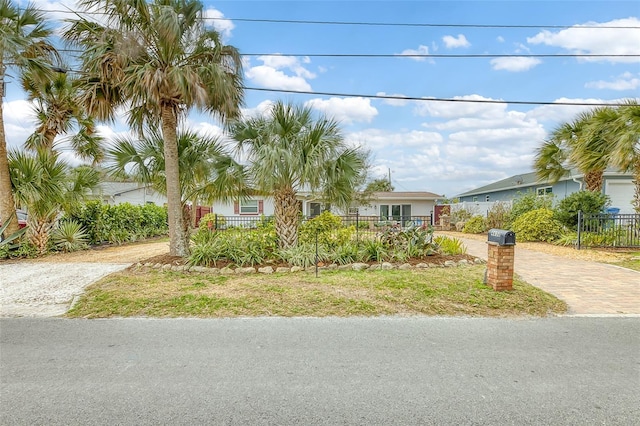 view of front of house with decorative driveway and fence