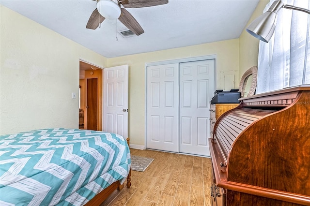 bedroom featuring visible vents, baseboards, a ceiling fan, light wood-style floors, and a closet