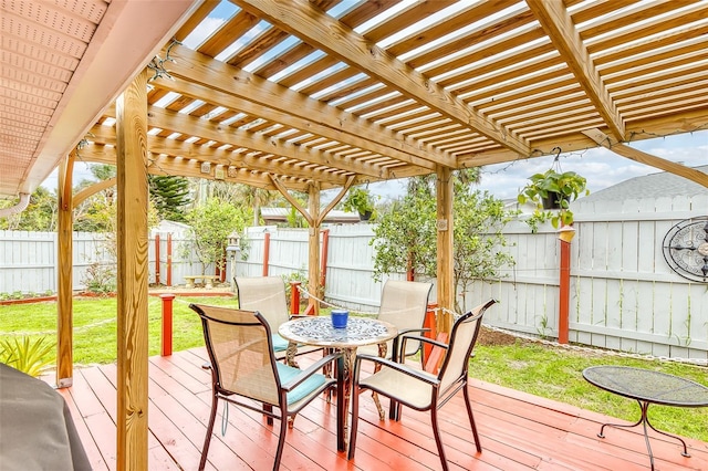 wooden terrace featuring outdoor dining space, a fenced backyard, a lawn, and a pergola