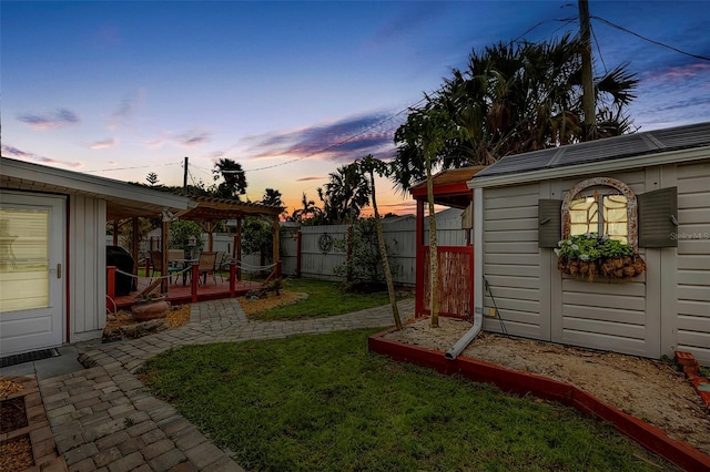 view of yard with fence, an outbuilding, a pergola, and a wooden deck