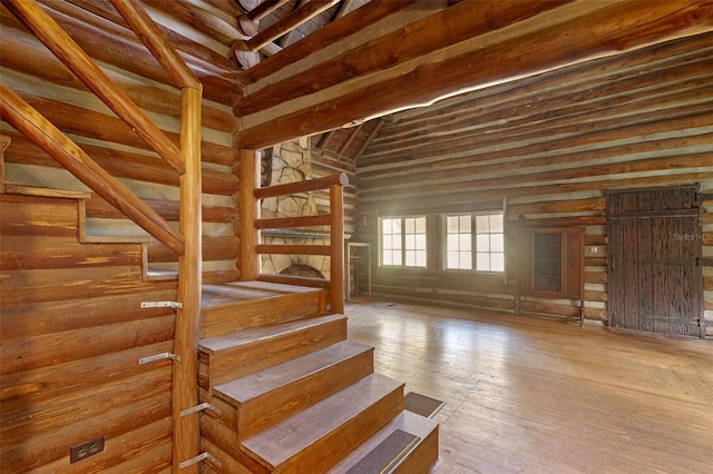 staircase featuring high vaulted ceiling and hardwood / wood-style floors