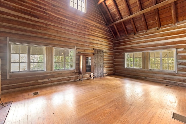 unfurnished living room with plenty of natural light, high vaulted ceiling, wood ceiling, and light hardwood / wood-style flooring