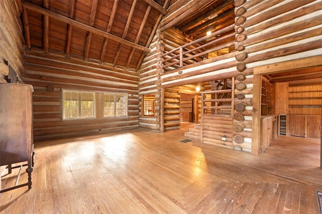 unfurnished living room featuring wood-type flooring, high vaulted ceiling, beamed ceiling, and wooden ceiling