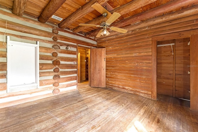 unfurnished living room with ceiling fan, hardwood / wood-style floors, wooden ceiling, and beam ceiling