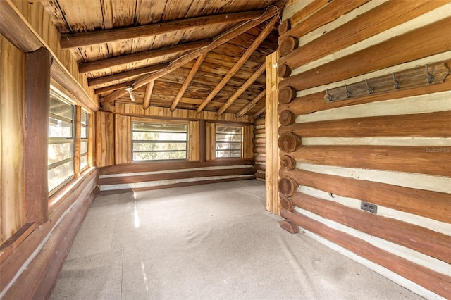 interior space featuring lofted ceiling with beams, log walls, and wood ceiling