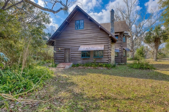 rear view of property featuring a yard