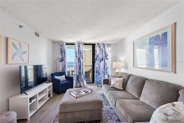 living room featuring floor to ceiling windows, hardwood / wood-style floors, and a textured ceiling