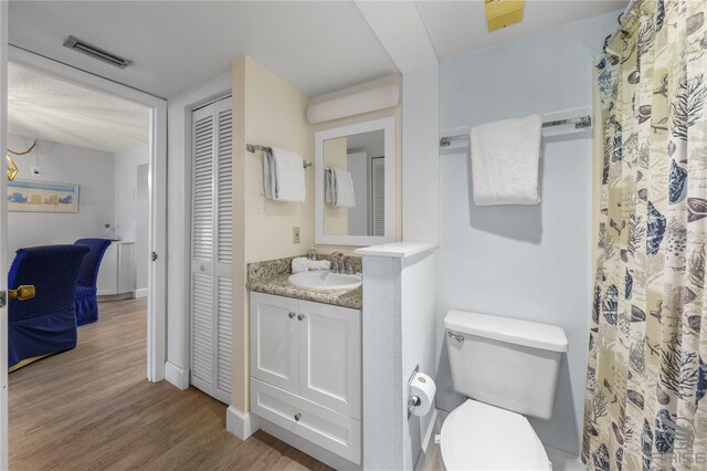 bathroom with vanity, hardwood / wood-style floors, and toilet