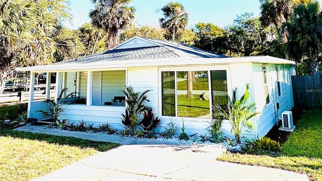 view of front of home featuring ac unit, a front yard, and covered porch