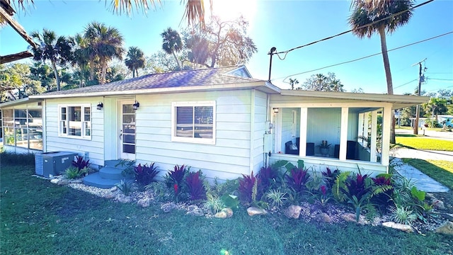 exterior space with central AC unit and a yard