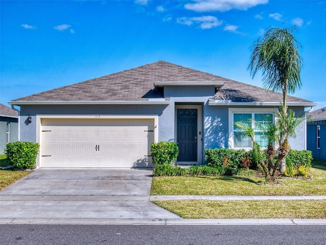 view of front of property featuring a garage and a front lawn