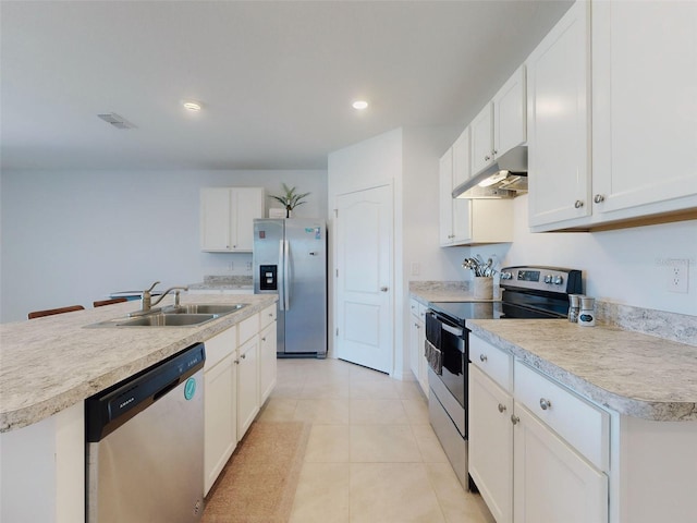 kitchen featuring appliances with stainless steel finishes, sink, a kitchen island with sink, and white cabinets