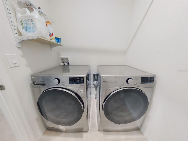 clothes washing area with washing machine and dryer