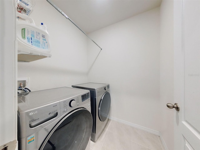 laundry room featuring separate washer and dryer and light tile patterned floors