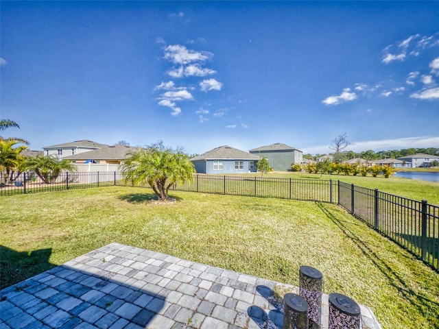 view of yard with a water view and a patio