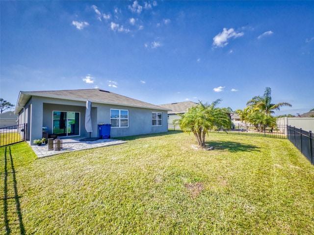 rear view of house featuring a yard and a patio area