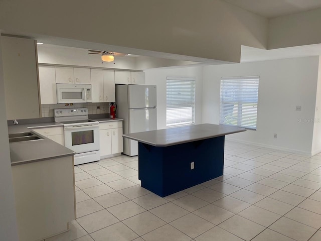 kitchen with decorative backsplash, a sink, white appliances, and light tile patterned floors
