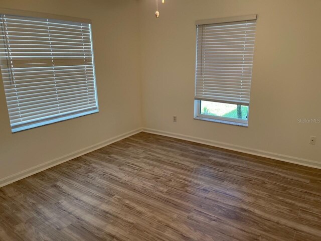 empty room with baseboards and wood finished floors