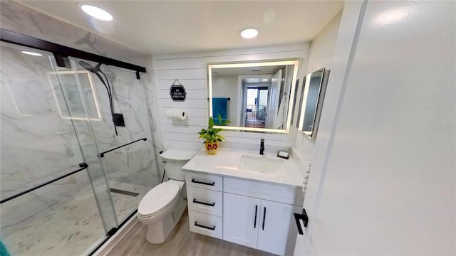 bathroom with hardwood / wood-style flooring, vanity, toilet, and walk in shower