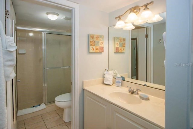 bathroom with an enclosed shower, vanity, tile patterned flooring, and toilet