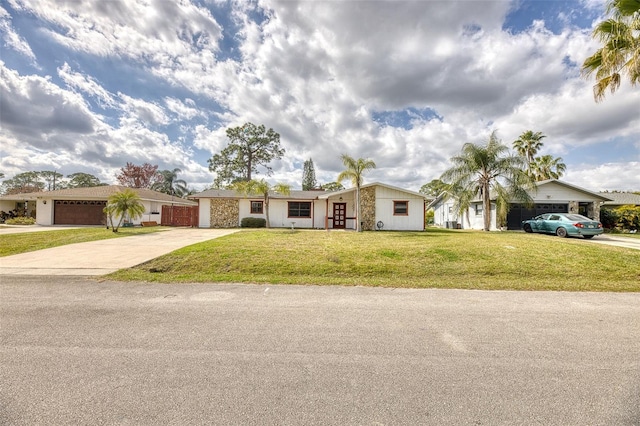 ranch-style home with a garage and a front lawn