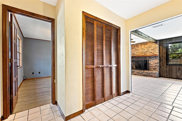 corridor with light tile patterned flooring and wood walls