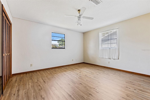 interior space with ceiling fan, a textured ceiling, and light hardwood / wood-style floors