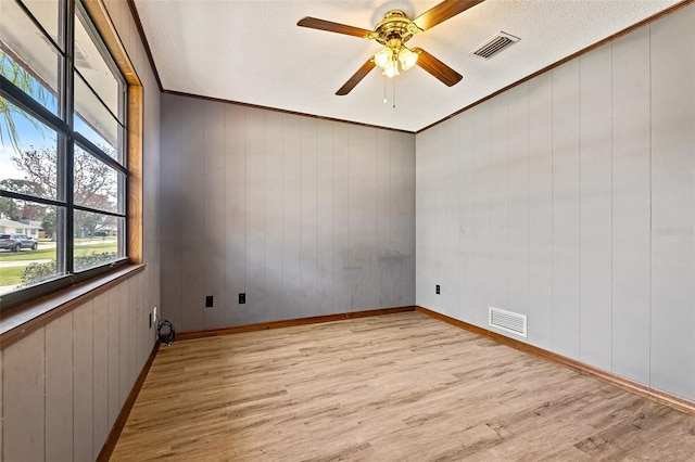 spare room featuring ornamental molding, a textured ceiling, ceiling fan, and light hardwood / wood-style floors