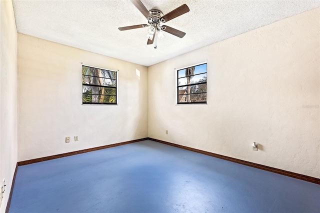 empty room with ceiling fan, concrete flooring, and a textured ceiling