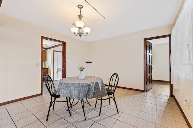 dining area with light tile patterned flooring and a chandelier