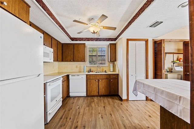 kitchen with sink, white appliances, ceiling fan, a textured ceiling, and light hardwood / wood-style flooring