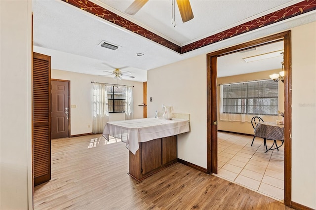 kitchen featuring ceiling fan, a textured ceiling, and light wood-type flooring