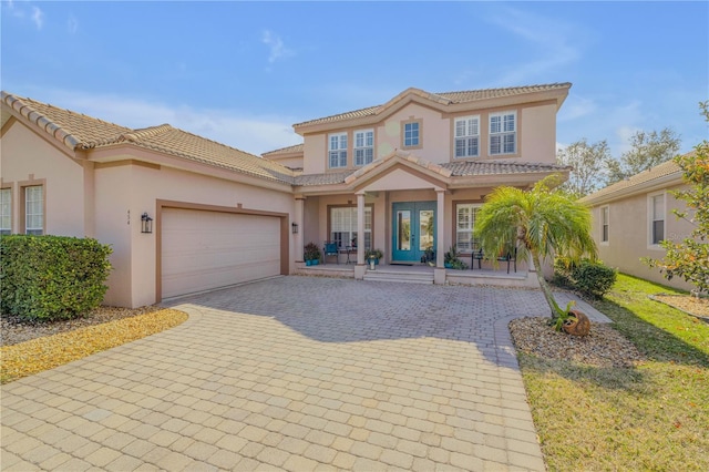 mediterranean / spanish-style house featuring a garage and a porch