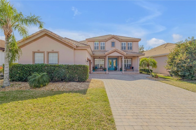 mediterranean / spanish-style home with a front lawn and french doors