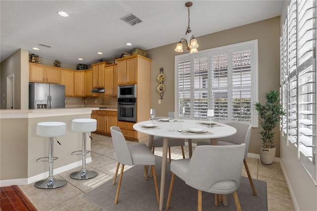 dining space with a notable chandelier and light tile patterned floors