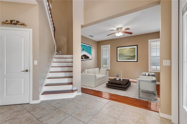 stairs featuring a wealth of natural light, tile patterned floors, and ceiling fan