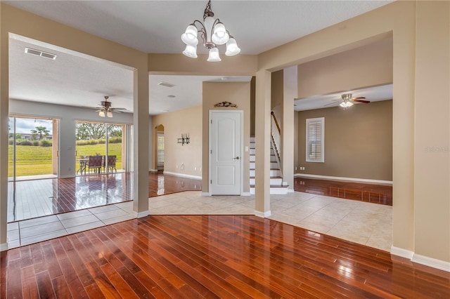 interior space with ceiling fan with notable chandelier and light hardwood / wood-style flooring