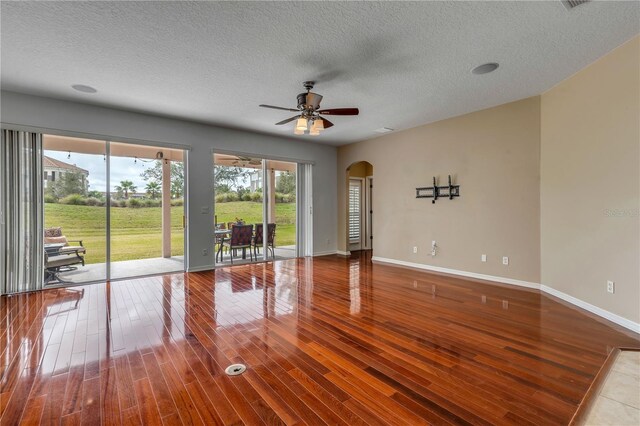 unfurnished room featuring a textured ceiling, wood-type flooring, and ceiling fan