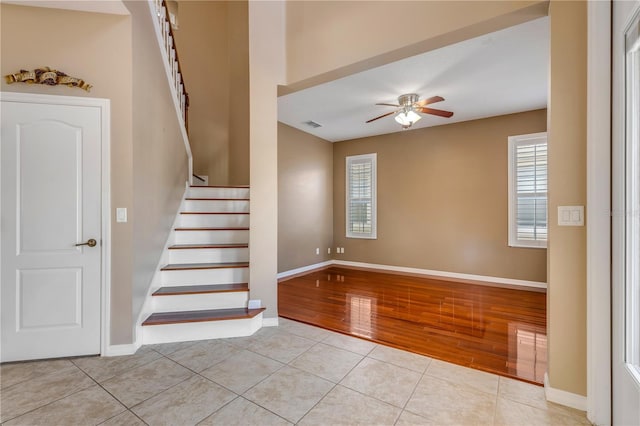 staircase with ceiling fan, tile patterned floors, and a healthy amount of sunlight