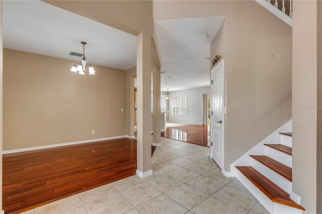 tiled entrance foyer with a notable chandelier