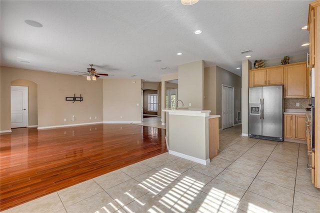 kitchen with sink, light tile patterned floors, stainless steel fridge, and decorative backsplash