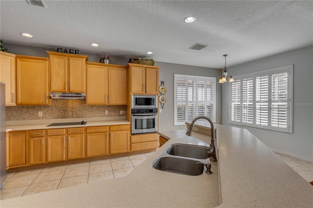 kitchen featuring sink, light tile patterned floors, appliances with stainless steel finishes, decorative backsplash, and decorative light fixtures