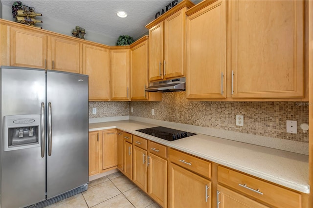 kitchen featuring tasteful backsplash, stainless steel fridge, black electric cooktop, light tile patterned floors, and a textured ceiling