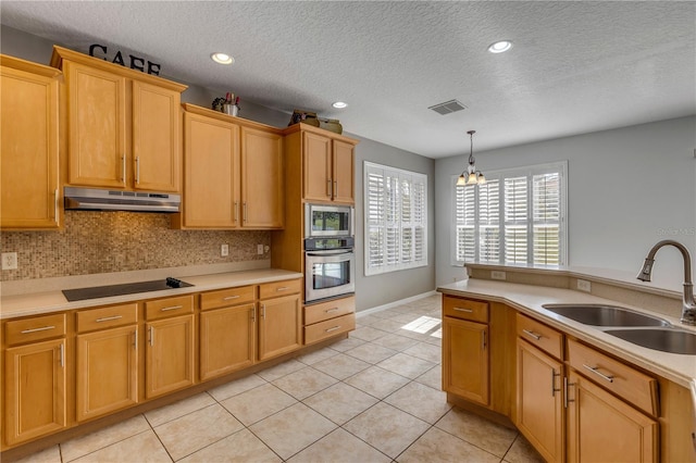 kitchen featuring appliances with stainless steel finishes, decorative light fixtures, tasteful backsplash, sink, and light tile patterned floors