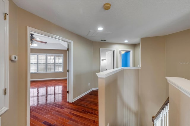 hall with hardwood / wood-style floors and a textured ceiling