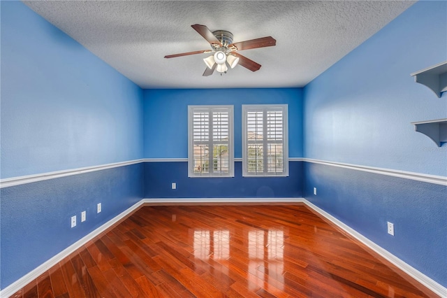 empty room with a textured ceiling, wood-type flooring, and ceiling fan